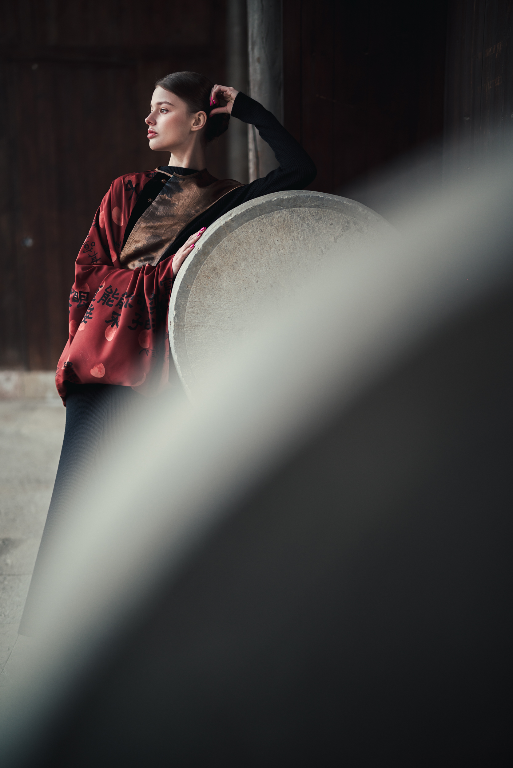 na pierwszym planie efekt bokeh, na drugim planie modelka w czerwonym stroju
